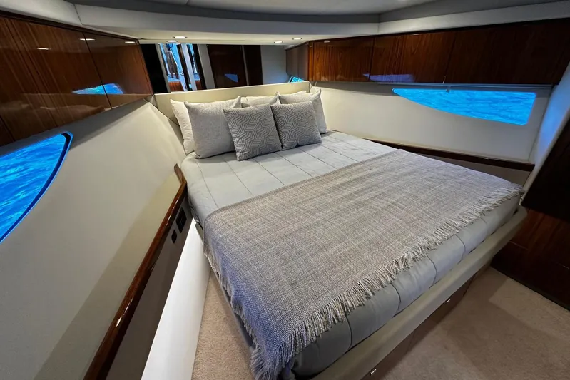  Yacht Photos Pics Luxurious bedroom interior of 2023 Riviera 465 SUV yacht with elegant bedding and wood accents.