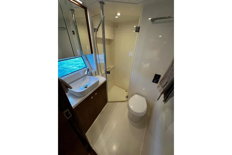  Yacht Photos Pics Luxurious bathroom in 2023 Riviera 465 SUV yacht with modern fixtures and ocean view.