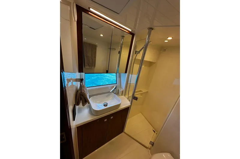 Yacht Photos Pics Luxurious bathroom in 2023 Riviera 465 SUV yacht with modern fixtures and ocean view.