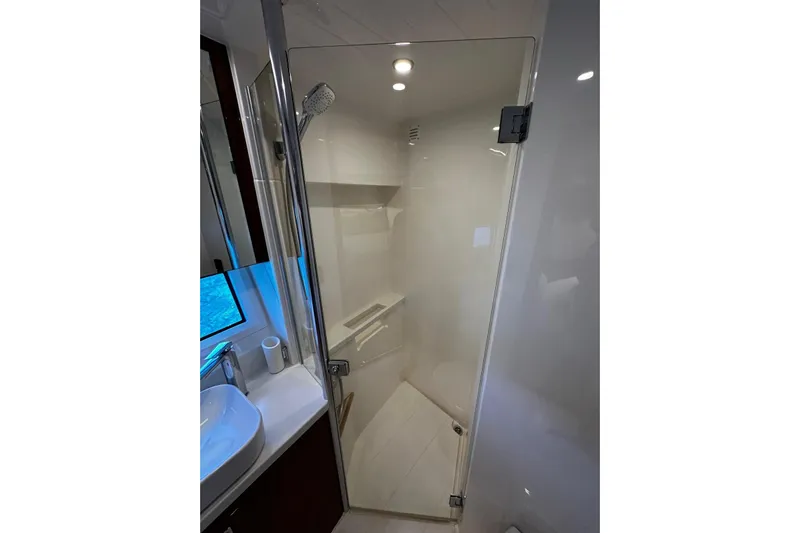  Yacht Photos Pics Modern bathroom in 2023 Riviera 465 SUV yacht with glass shower enclosure.
