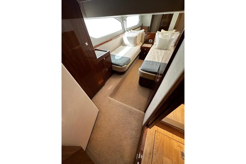  Yacht Photos Pics Luxurious interior of 2023 Riviera 465 SUV yacht with twin beds and elegant wood finish.
