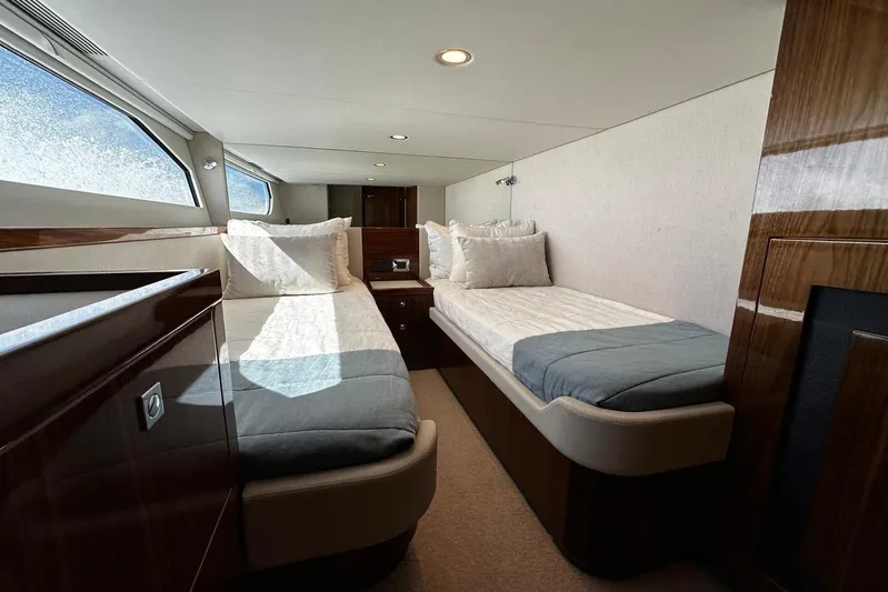  Yacht Photos Pics Luxurious interior of 2023 Riviera 465 SUV yacht with twin beds and elegant wood finish.