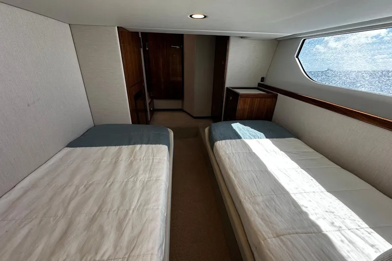 Yacht Photos Pics 2023 Riviera 465 SUV cabin with twin beds and ocean view window.