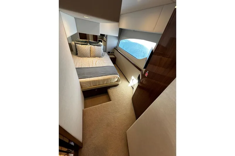  Yacht Photos Pics Luxurious bedroom interior of 2023 Riviera 465 SUV yacht with large window and elegant decor.