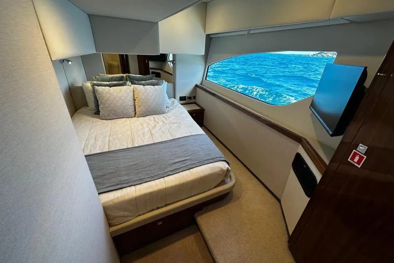  Yacht Photos Pics Luxurious bedroom interior of 2023 Riviera 465 SUV yacht with ocean view window.