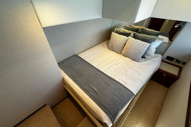  Yacht Photos Pics Luxurious bedroom interior of 2023 Riviera 465 SUV yacht with elegant bedding and cushions.