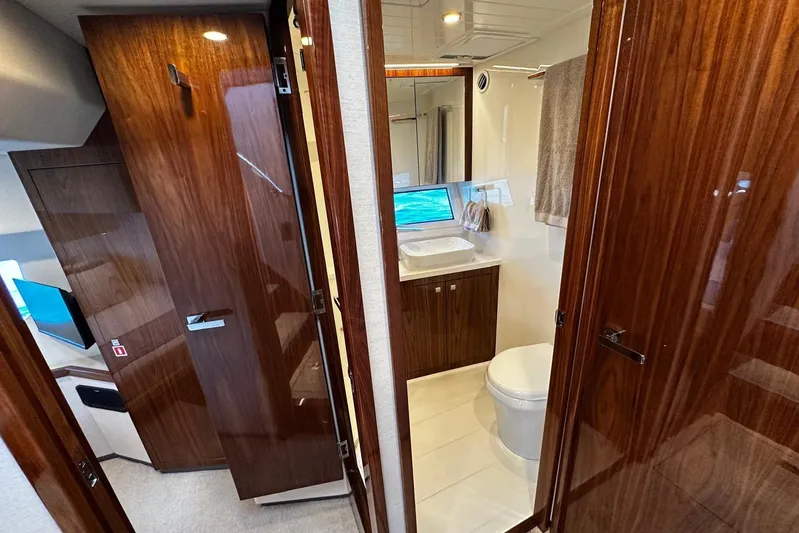  Yacht Photos Pics Luxurious bathroom interior of 2023 Riviera 465 SUV yacht with wooden finishes.