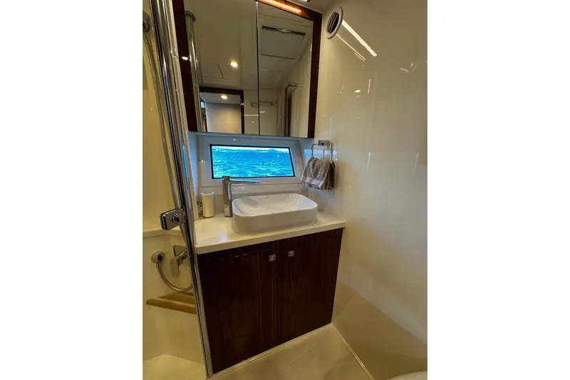  Yacht Photos Pics Luxurious bathroom in 2023 Riviera 465 SUV yacht with modern sink and ocean view.