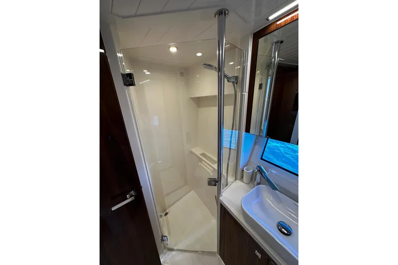  Yacht Photos Pics Luxurious bathroom in 2023 Riviera 465 SUV yacht with modern shower and sleek sink design.