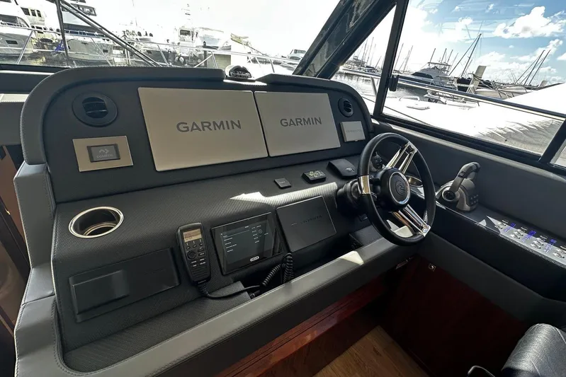  Yacht Photos Pics 2023 Riviera 465 SUV helm with Garmin navigation, steering wheel, and control panel.