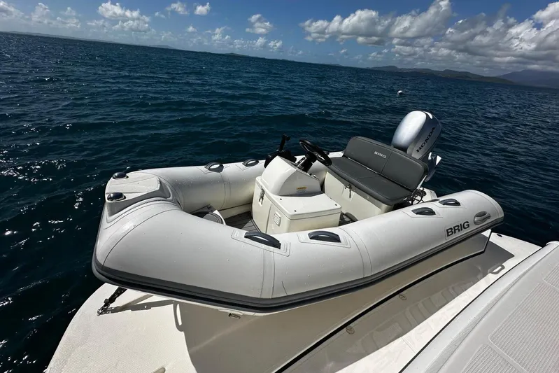  Yacht Photos Pics 2023 Riviera 465 SUV with Brig inflatable boat on ocean, under clear skies.