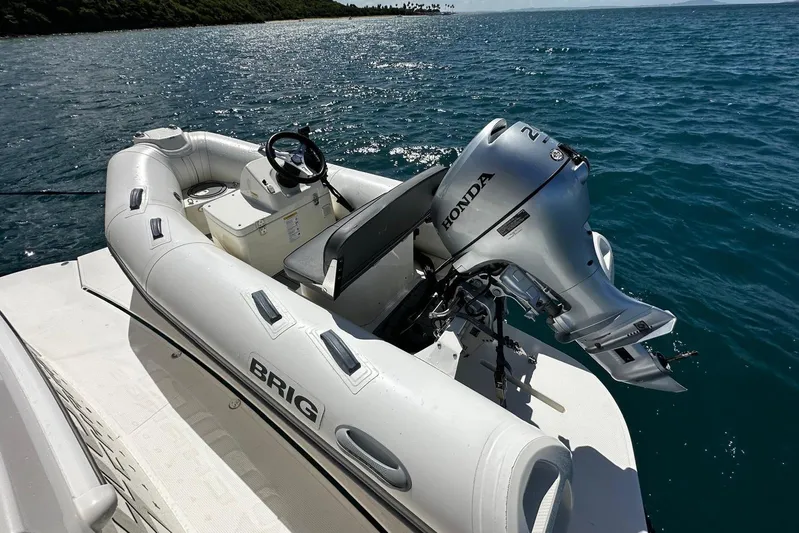  Yacht Photos Pics Inflatable boat with Honda motor on Riviera 465 SUV, 2023, in sunny ocean setting.