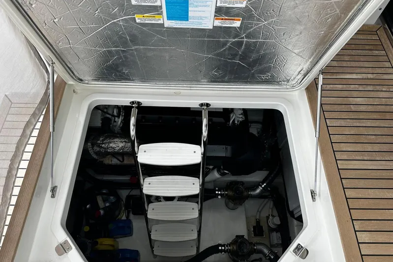  Yacht Photos Pics Engine compartment of 2023 Riviera 465 SUV with open hatch and visible ladder.