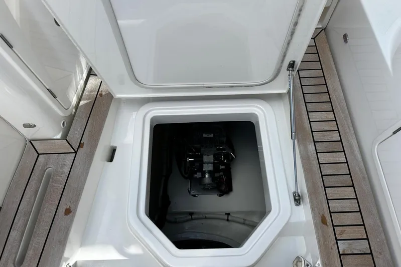  Yacht Photos Pics Open hatch on 2023 Riviera 465 SUV, revealing engine compartment with wooden deck surroundings.