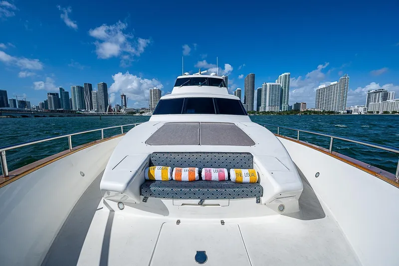 The Usual Yacht Photos Pics Luxury Horizon 82 yacht cruising near city skyline, clear blue sky, 2000 model.