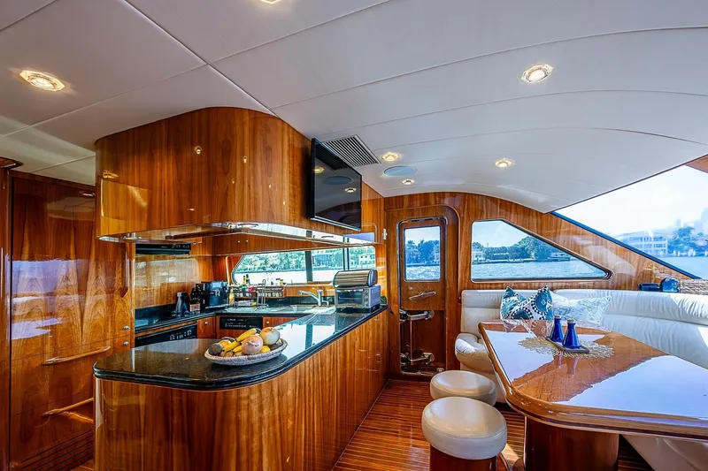 The Usual Yacht Photos Pics Luxurious interior of 2000 Horizon 82 yacht with elegant wood finishes and modern kitchen.