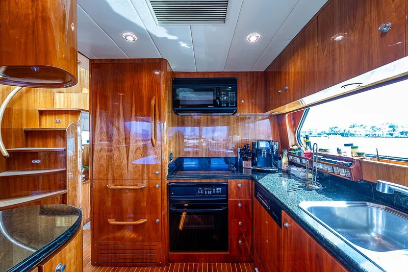 The Usual Yacht Photos Pics Luxurious yacht kitchen interior with wooden cabinetry, modern appliances, and ocean view. Horizon 82, 2000 model.