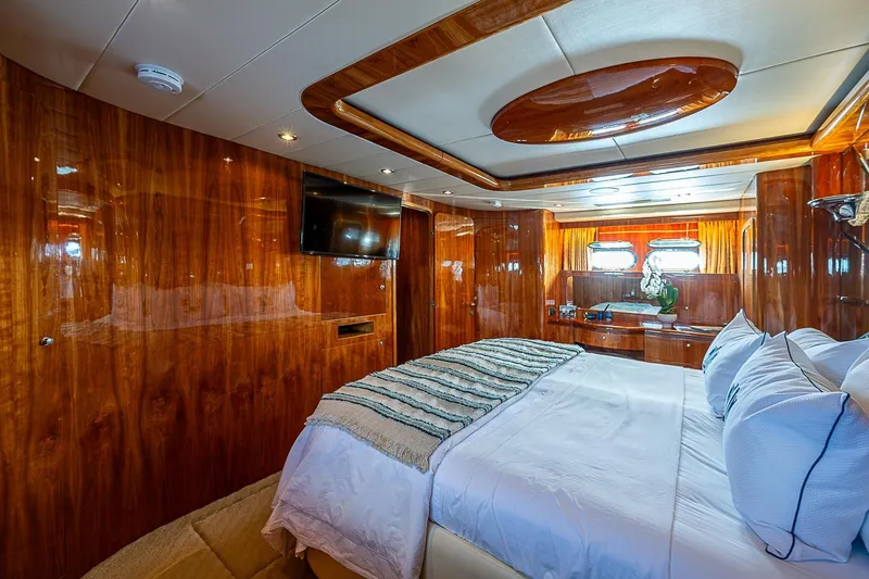 The Usual Yacht Photos Pics Luxurious bedroom interior on 2000 Horizon 82 yacht with wood paneling and modern amenities.