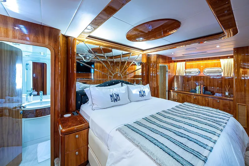 The Usual Yacht Photos Pics Luxurious bedroom interior on 2000 Horizon 82 yacht with elegant wood finishes and modern amenities.