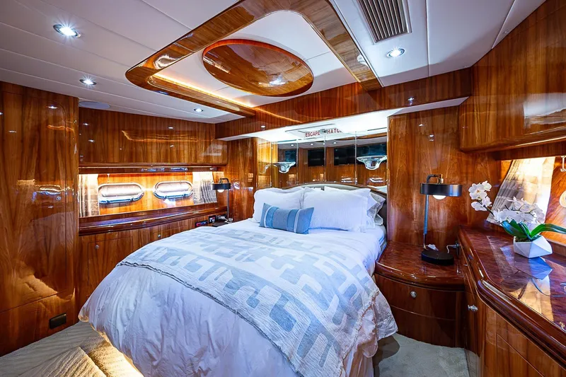 The Usual Yacht Photos Pics Luxurious cabin interior of 2000 Horizon 82 yacht with elegant wood finish and cozy bedding.