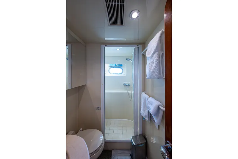 The Usual Yacht Photos Pics Compact yacht bathroom with shower, towels, and porthole on Horizon 82, year 2000.