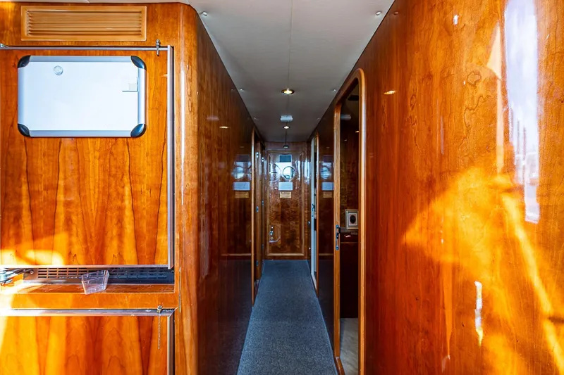The Usual Yacht Photos Pics Luxurious wooden interior hallway of 2000 Horizon 82 yacht, featuring polished walls and modern design.