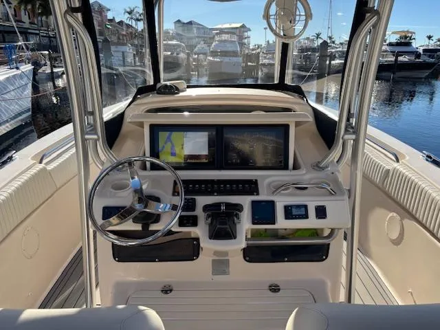 Get Hot Yacht Photos Pics 2011 Grady-White Canyon 306 boat cockpit with steering wheel and navigation screens.