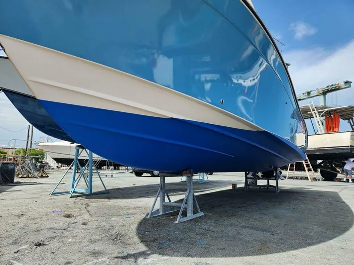 Get Hot Yacht Photos Pics 2011 Grady-White Canyon 306 boat on stands, blue hull, outdoor setting.