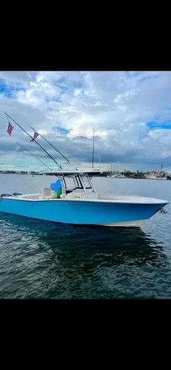 Get Hot Yacht Photos Pics 2011 Grady-White Canyon 306 boat on calm water under cloudy sky.