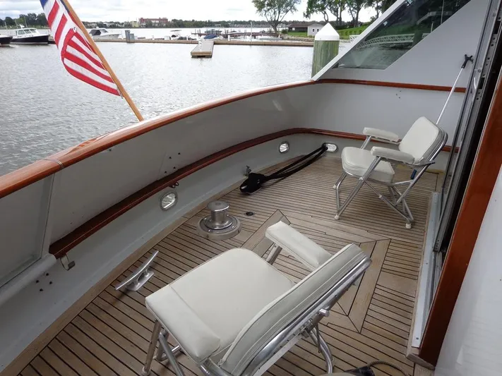 Yacht Photos Pics 1988 Burger 80 Motor Yacht deck with chairs and American flag, docked by the water.