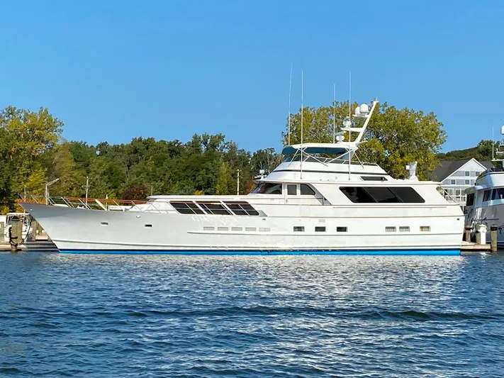  Yacht Photos Pics 1988 Burger 80 Motor Yacht docked on a sunny day, surrounded by trees and calm water.