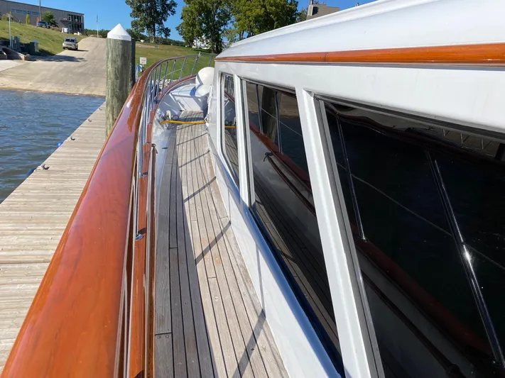  Yacht Photos Pics Side view of a 1988 Burger 80 Motor Yacht docked, showcasing sleek design and polished woodwork.
