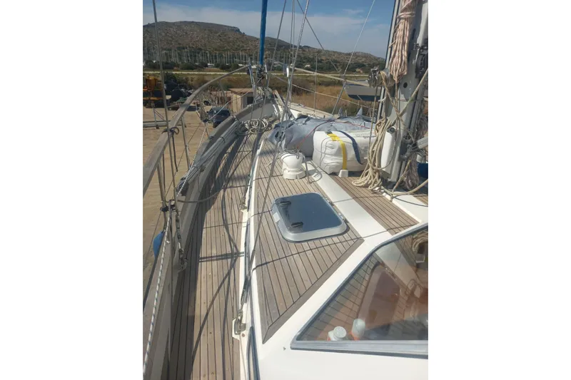  Yacht Photos Pics Siltala Nauticat 38 sailboat deck, 1994 model, with ropes and equipment, docked near hills.