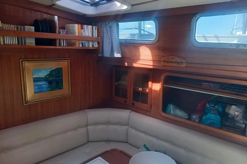  Yacht Photos Pics Cozy interior of 1994 Siltala Nauticat 38 sailboat with books, painting, and seating area.
