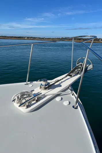 Tomahawk Yacht Photos Pics Bow of 2011 Flowers Hardtop boat on calm water under clear blue sky.