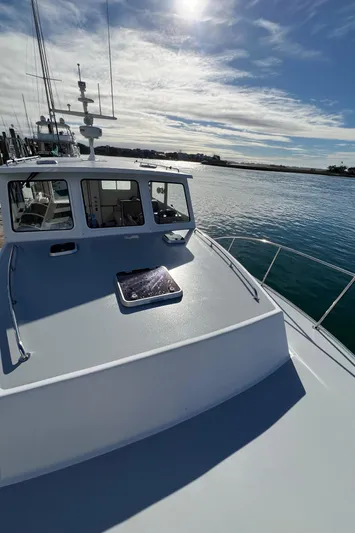 Tomahawk Yacht Photos Pics 2011 Flowers Hardtop boat on calm water under a sunny sky.