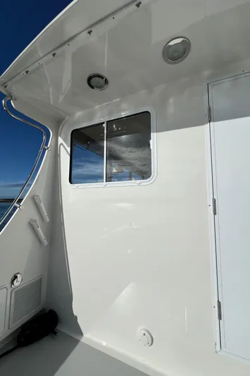 Tomahawk Yacht Photos Pics 2011 Flowers Hardtop boat exterior with window and door under clear sky.