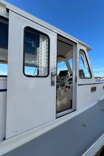Tomahawk Yacht Photos Pics 2011 Flowers Hardtop boat with sliding door and visible cockpit, under clear blue sky.