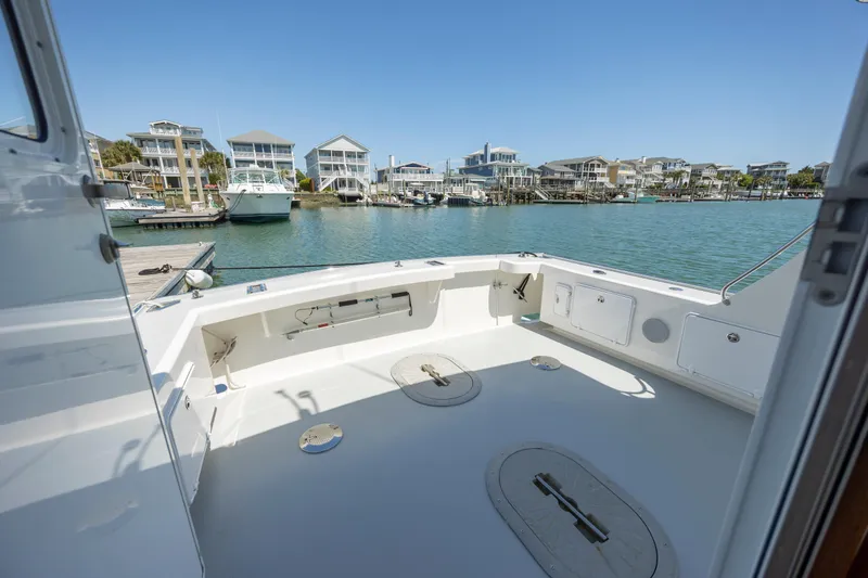 Tomahawk Yacht Photos Pics 2011 Flowers Hardtop boat deck with waterfront view and docked boats.