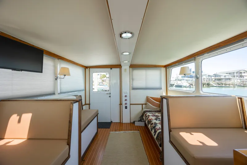 Tomahawk Yacht Photos Pics Interior of a 2011 Flowers Hardtop boat with seating, windows, and a TV.