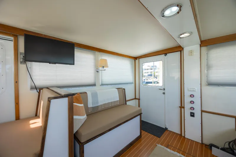 Tomahawk Yacht Photos Pics Interior of a 2011 Flowers Hardtop boat with seating, TV, and door.