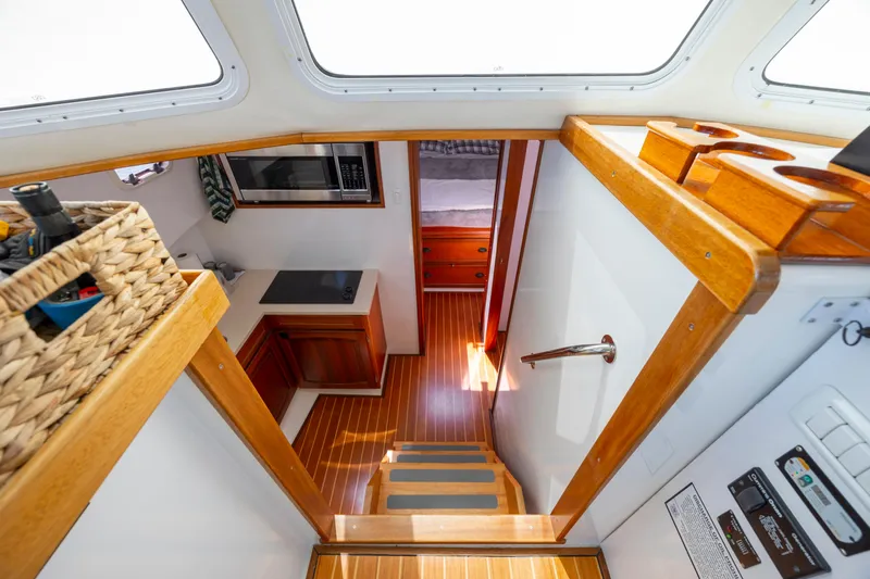 Tomahawk Yacht Photos Pics Interior of 2011 Flowers Hardtop boat with wooden flooring and compact kitchen area.