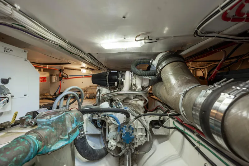 Tomahawk Yacht Photos Pics Engine room of a 2011 Flowers Hardtop boat, showcasing complex machinery and piping.