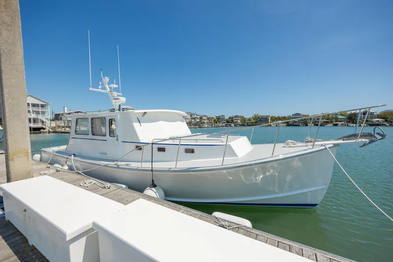 Tomahawk Yacht Photos Pics White 2011 Flowers Hardtop boat docked in a sunny marina.