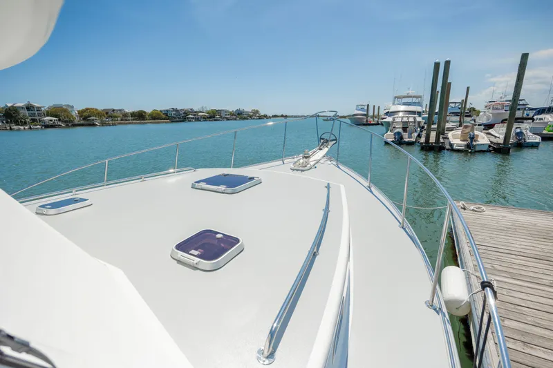 Tomahawk Yacht Photos Pics Luxury yacht docked at marina, clear blue sky, calm waters, 2011 Flowers Hardtop model.