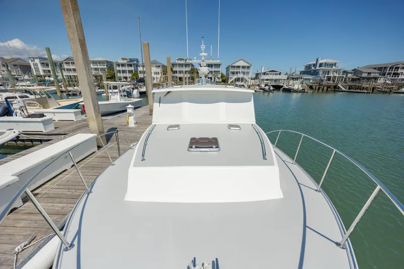 Tomahawk Yacht Photos Pics 2011 Flowers Hardtop boat docked at marina with waterfront homes in background.
