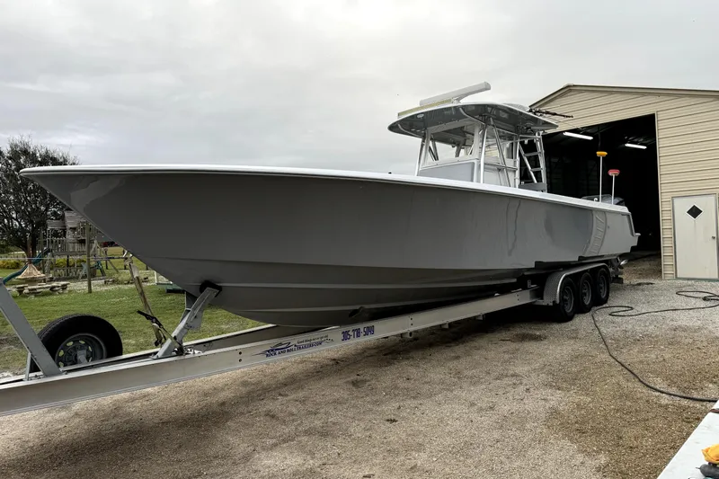  Yacht Photos Pics 2014 Contender 39 ST boat on trailer near a storage building.
