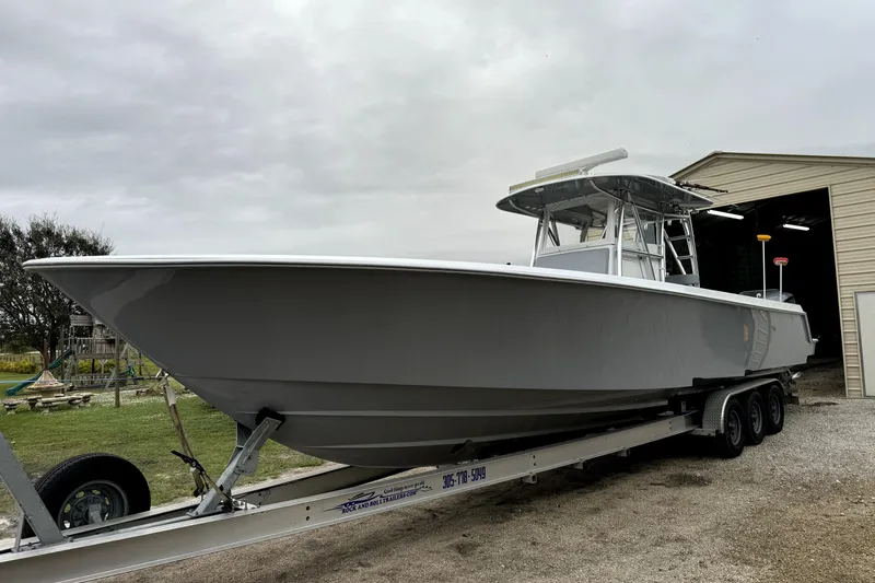  Yacht Photos Pics 2014 Contender 39 ST boat on trailer near a garage, overcast sky.