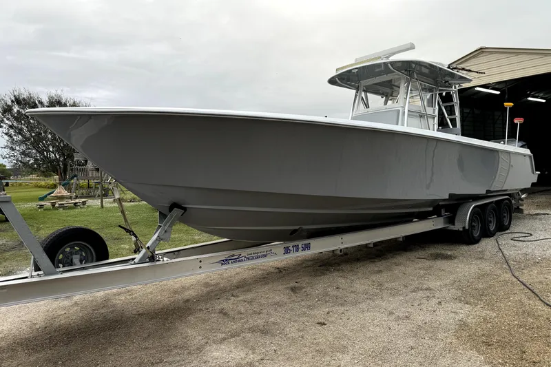  Yacht Photos Pics 2014 Contender 39 ST boat on trailer, parked outdoors near a shed.