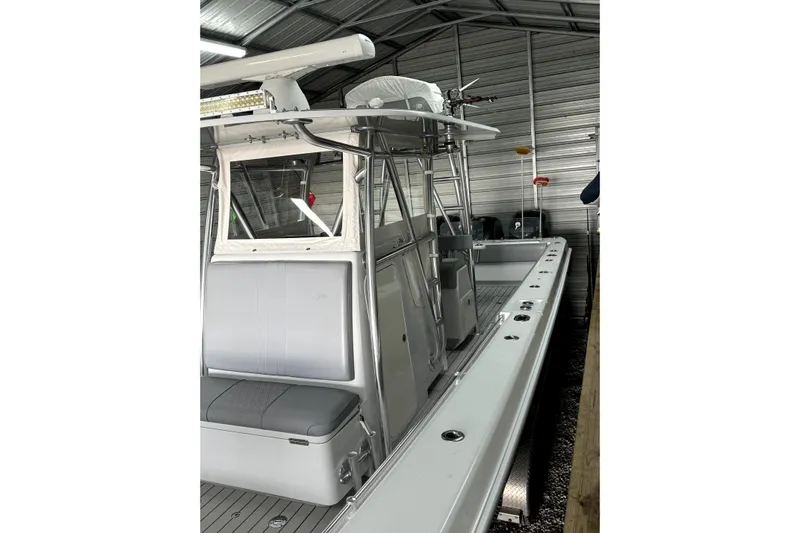  Yacht Photos Pics 2014 Contender 39 ST boat in a metal storage shed, showcasing sleek design and seating.